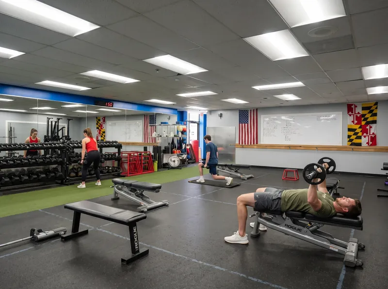 Members training on the turf strip in the Functional Training Room at Foundation Fitness Annapolis, with Maryland state flags on the wall
