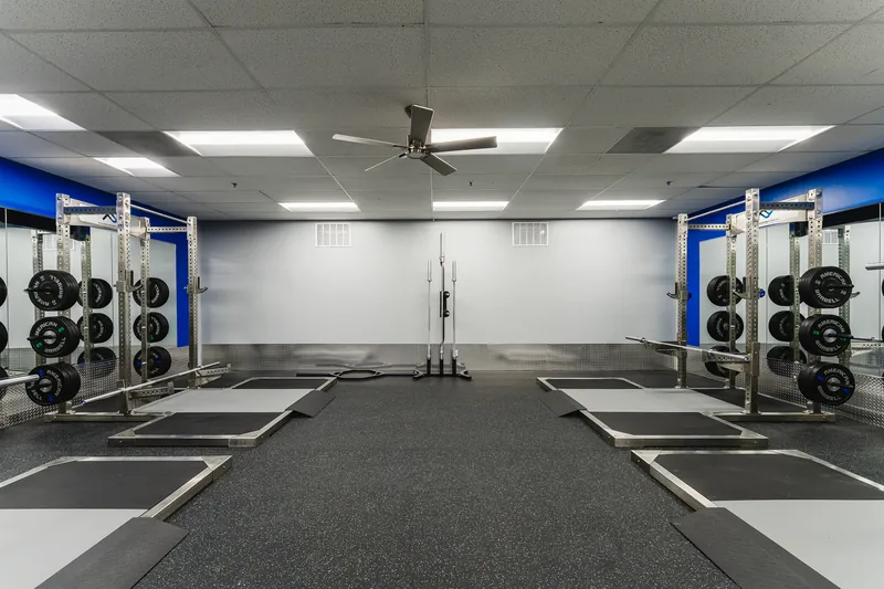 A row of lifting platforms and squat racks at Foundation Fitness Annapolis