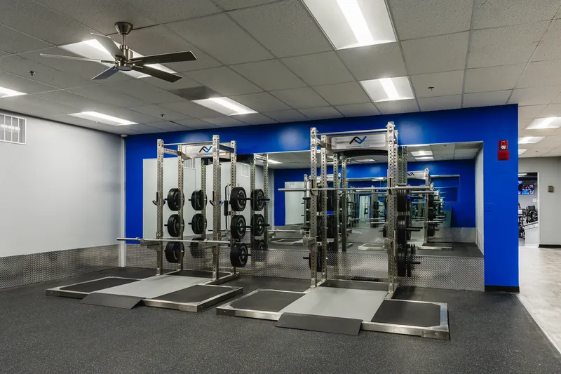 A row of new squat racks on lifting platforms at Foundation Fitness Annapolis