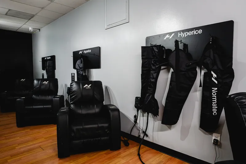 Normatec compression boots, Hyperice massage guns and recliners in the Recovery Room at Foundation Fitness Annapolis